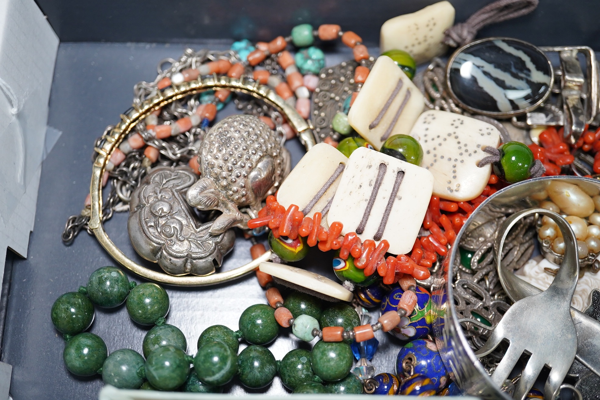 A quantity of assorted Victorian and later jewellery, including a 'Good Luck' oval locket, 9ct and garnet cluster brooch, a coral branch necklace, sterling bangle, part of a Chinese white metal buckle, Italian glass bead
